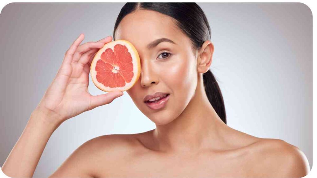 a person holding a grapefruit in front of their face