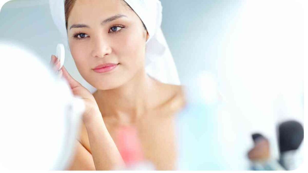 beautiful person with towel on their head in front of mirror